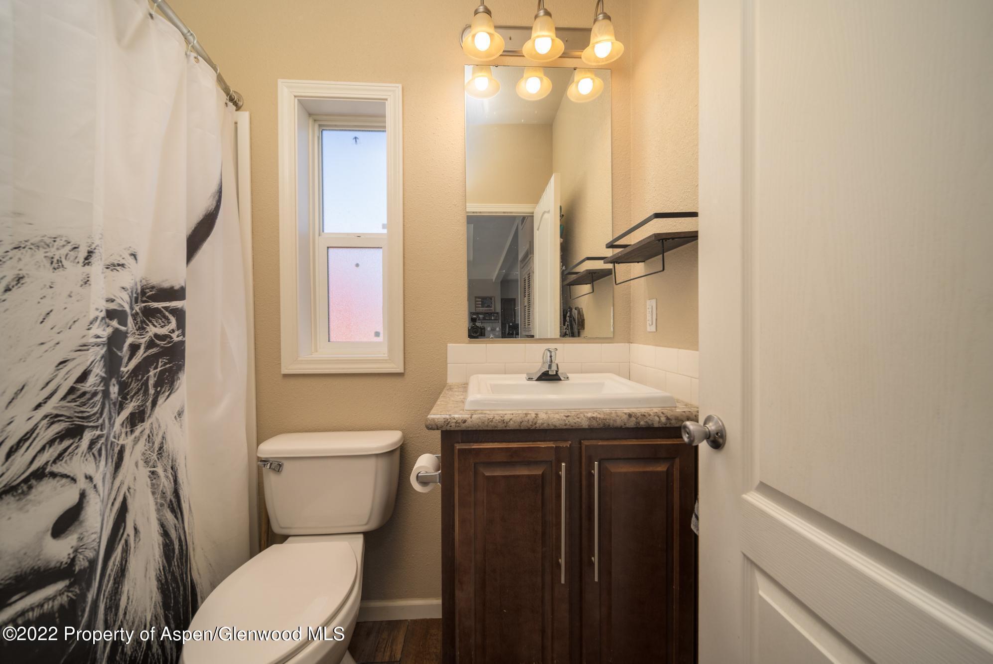 308 Cindys Way Rifle, CO 81650 - Photo 24 of 29 a bathroom with a granite countertop toilet sink and mirror