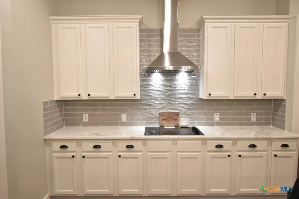 a kitchen with granite countertop white cabinets and white appliances