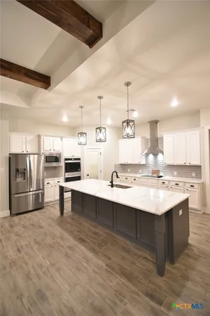 a kitchen with kitchen island stainless steel appliances a sink stove and refrigerator