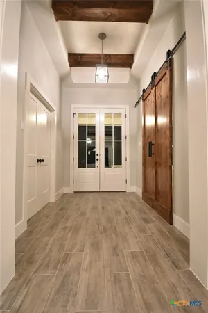 a view of empty room with wooden floor and windows
