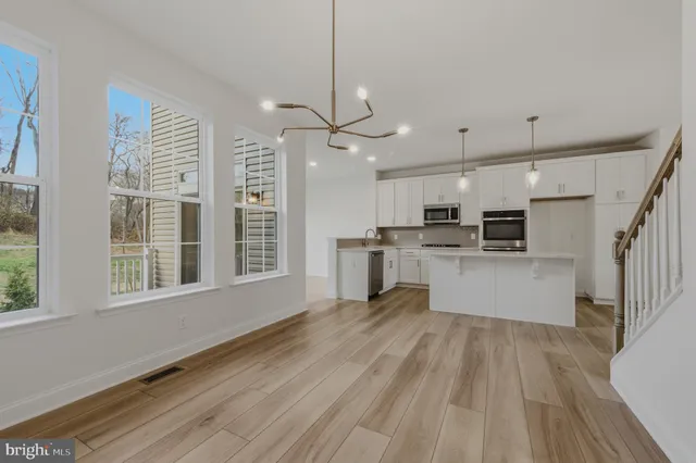 a view of kitchen with stainless steel appliances refrigerator oven and cabinets