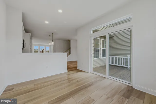 a view of empty room with wooden floor and windows