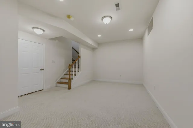 en empty room with stairs and white walls
