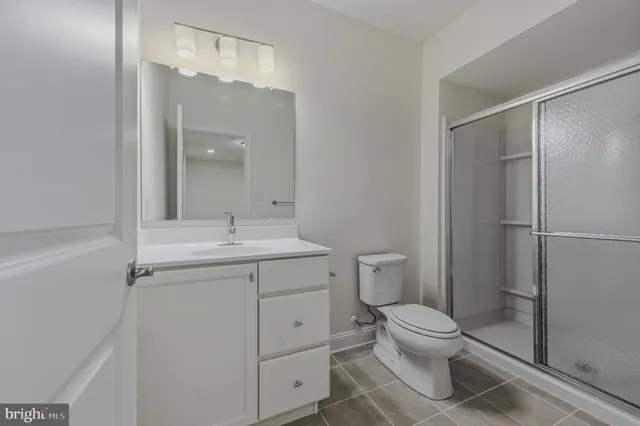 a bathroom with a toilet sink vanity and shower