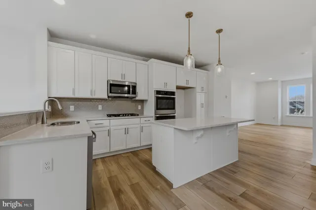 a kitchen with stainless steel appliances granite countertop a sink a stove a microwave and cabinets