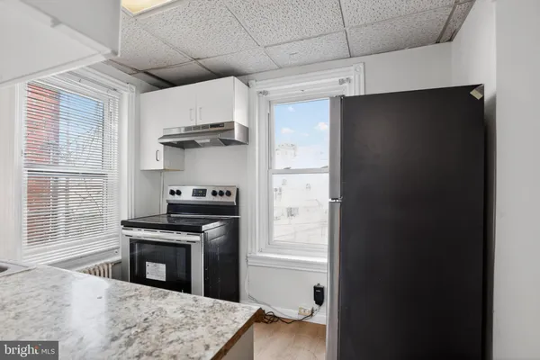 a kitchen with granite countertop white cabinets and a sink