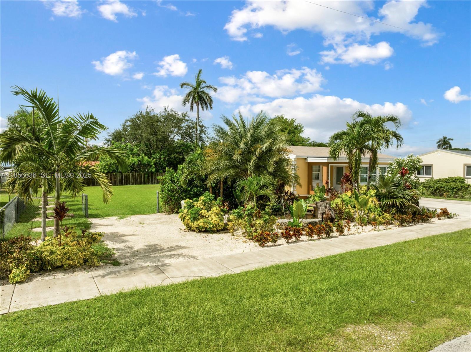 512 Northwest 13th Street Homestead, FL 33030 - Photo 37 of 39 a view of yellow house with a yard and potted plants