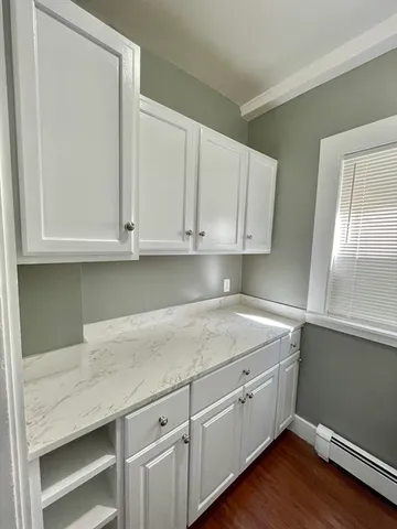 a kitchen with granite countertop white cabinets and sink
