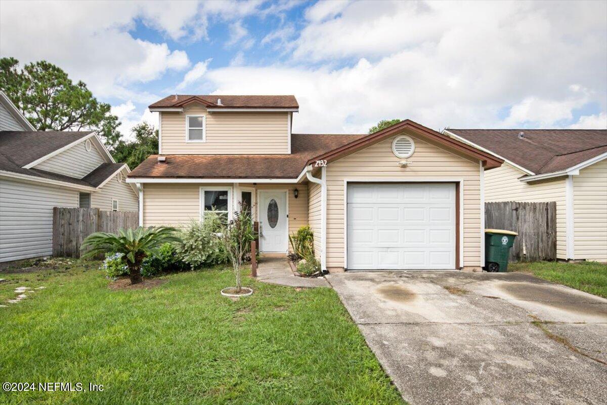 2432 Wattle Tree Road East Jacksonville, FL 32246 - Photo 1 of 25 a front view of a house with a yard and garage