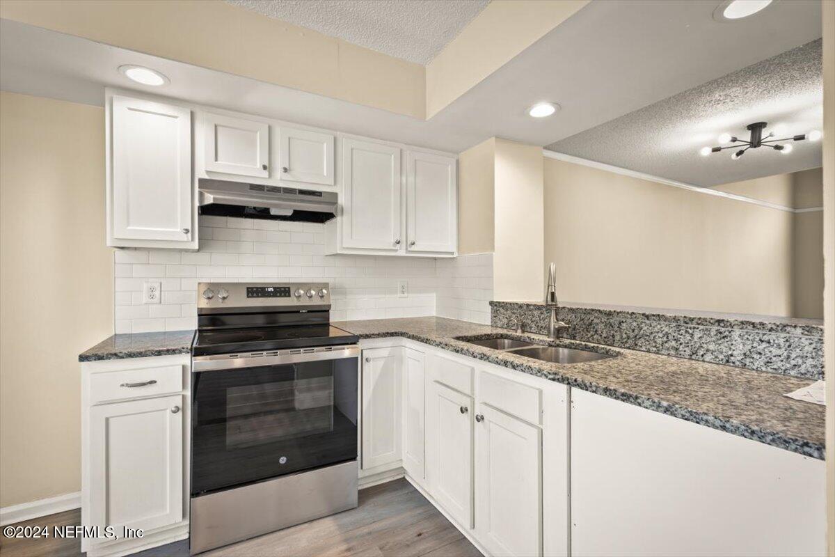 2432 Wattle Tree Road East Jacksonville, FL 32246 - Photo 11 of 25 a kitchen with stainless steel appliances granite countertop a stove sink and cabinets