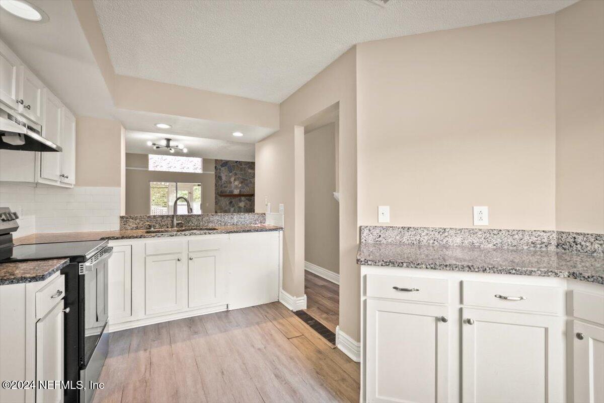 2432 Wattle Tree Road East Jacksonville, FL 32246 - Photo 12 of 25 a kitchen with granite countertop white cabinets and white appliances
