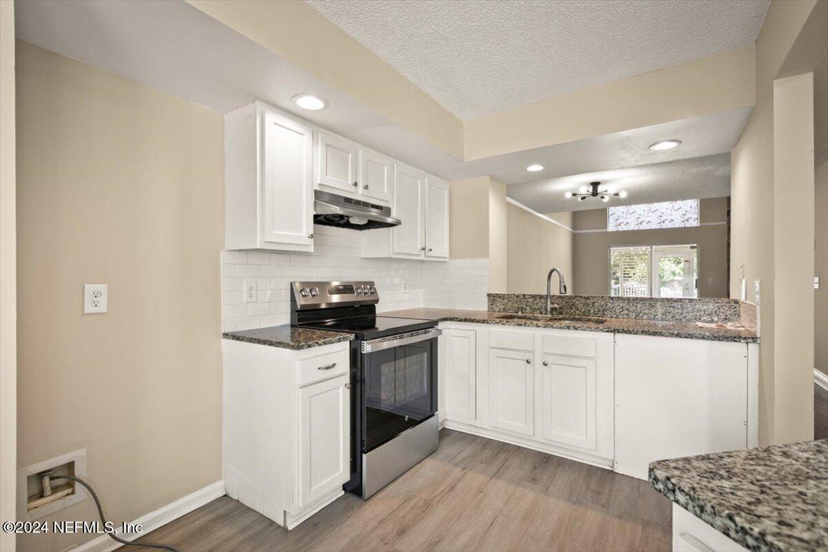 2432 Wattle Tree Road East Jacksonville, FL 32246 - Photo 13 of 25 a kitchen with stainless steel appliances granite countertop a sink stove and refrigerator