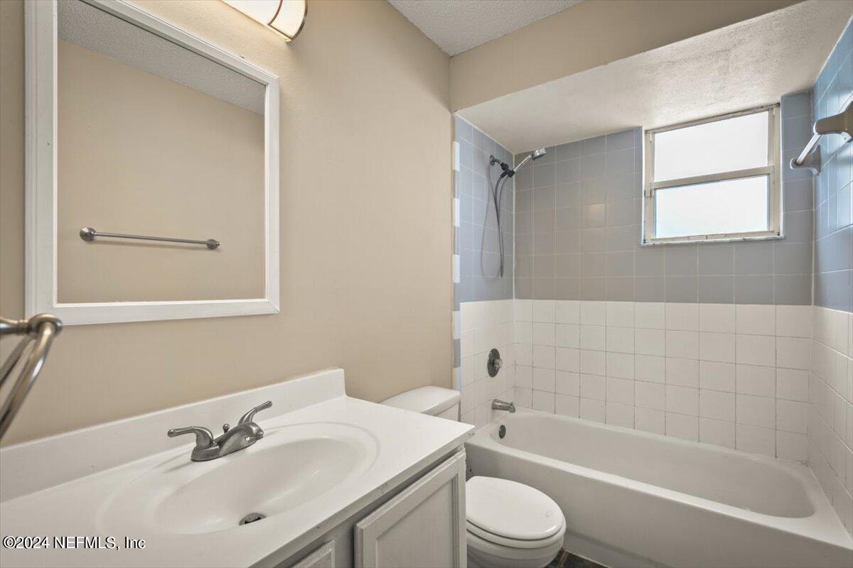 2432 Wattle Tree Road East Jacksonville, FL 32246 - Photo 16 of 25 a bathroom with a bathtub shower sink vanity mirror and toilet