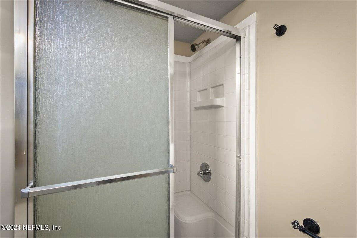 2432 Wattle Tree Road East Jacksonville, FL 32246 - Photo 24 of 25 a bathroom with a glass shower door