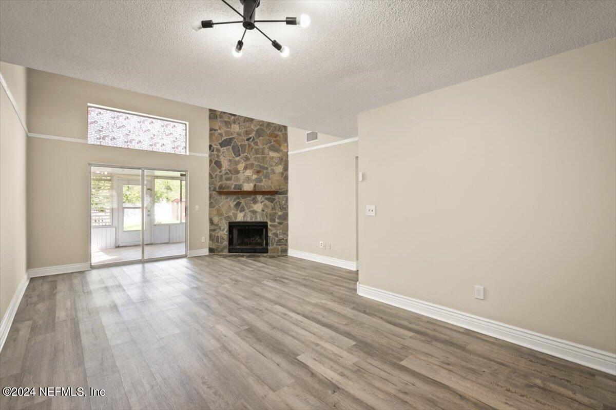 2432 Wattle Tree Road East Jacksonville, FL 32246 - Photo 8 of 25 an empty room with wooden floor fireplace and windows