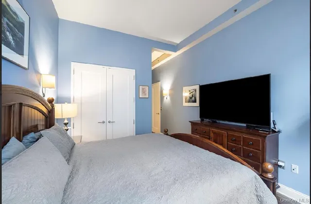 a bedroom with a bed and a flat screen tv