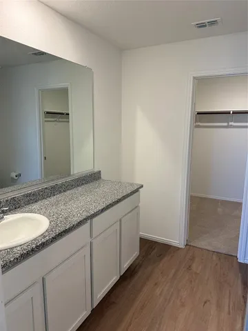 a bathroom with a granite countertop sink and a mirror