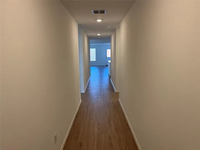 a view of a hallway with wooden floor and staircase