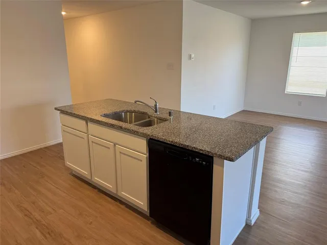 a kitchen with a sink a stove and cabinets