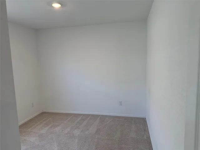 a view of a room with wooden floor and a window