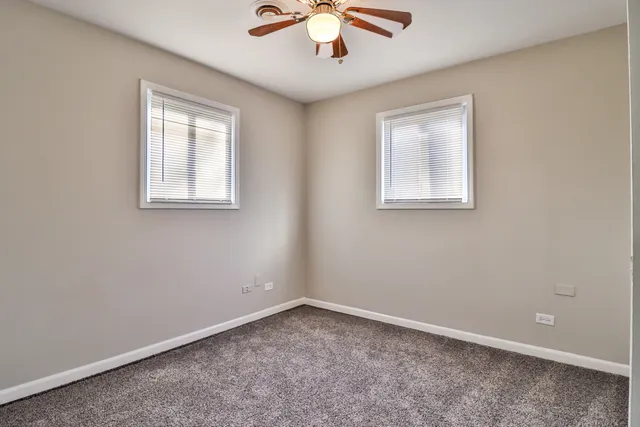 an empty room with a chandelier fan