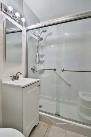 a bathroom with a shower sink vanity and mirror
