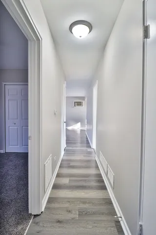 a view of a hallway with wooden floor and staircase