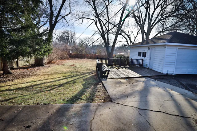 a view of a yard with wooden fence
