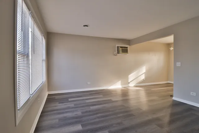 a view of empty room with wooden floor