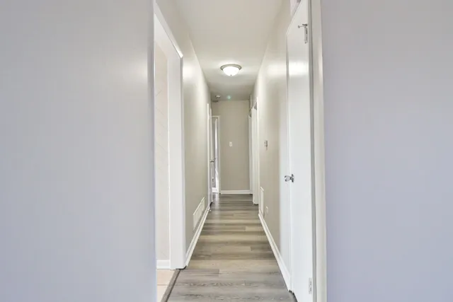 a view of a hallway with wooden floor
