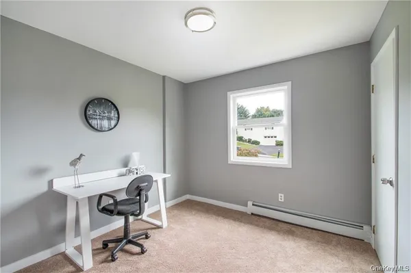 a view of room with workspace and windows
