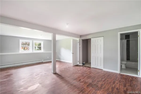 an empty room with windows and closet