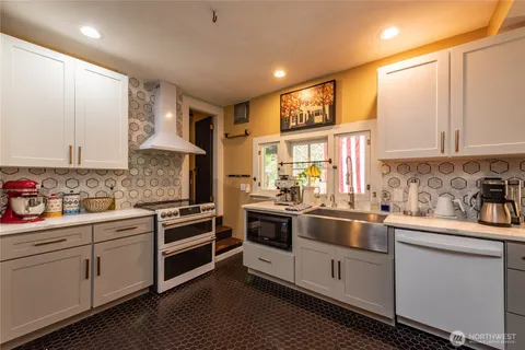a kitchen with white cabinets stainless steel appliances and sink
