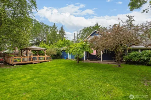 a view of a house with a big yard and large trees