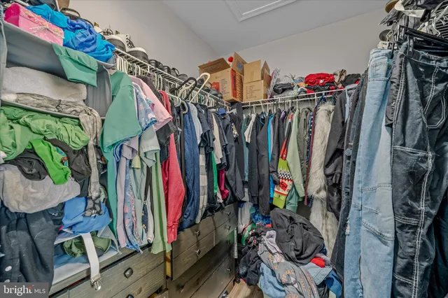a view of walk in closet with clothes