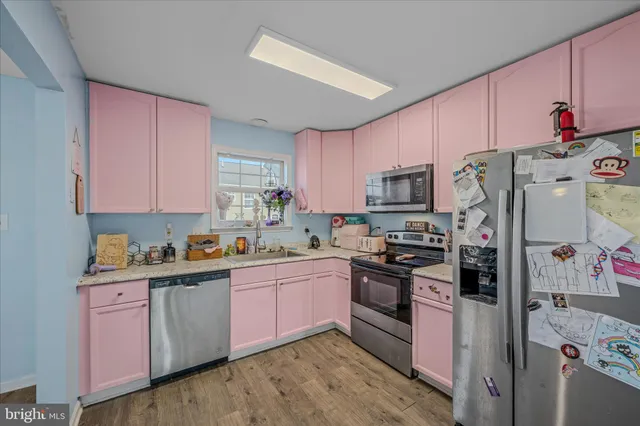 a kitchen with stainless steel appliances granite countertop a refrigerator stove top oven and sink