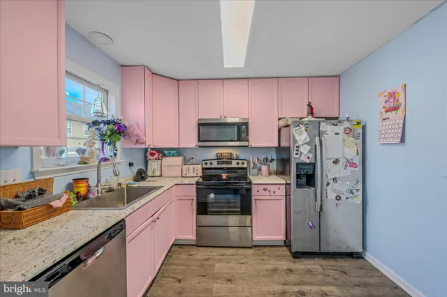 a kitchen with stainless steel appliances granite countertop a refrigerator sink and stove