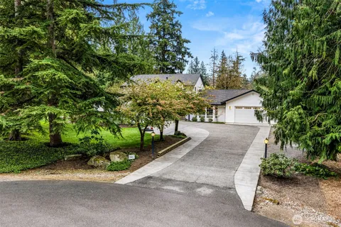 a front view of a house with a yard and green space
