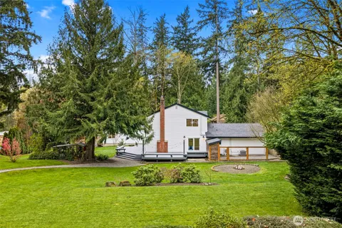 an aerial view of a house with a yard and large trees