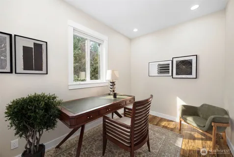 a view of a yard in front of a house with plants and large tree