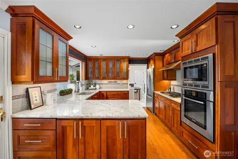 a kitchen with stainless steel appliances granite countertop a stove a sink and a microwave
