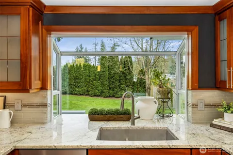 a living room with a floor to ceiling window and potted plant