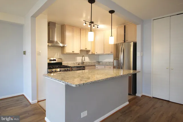 a kitchen with stainless steel appliances granite countertop a refrigerator a sink and a stove