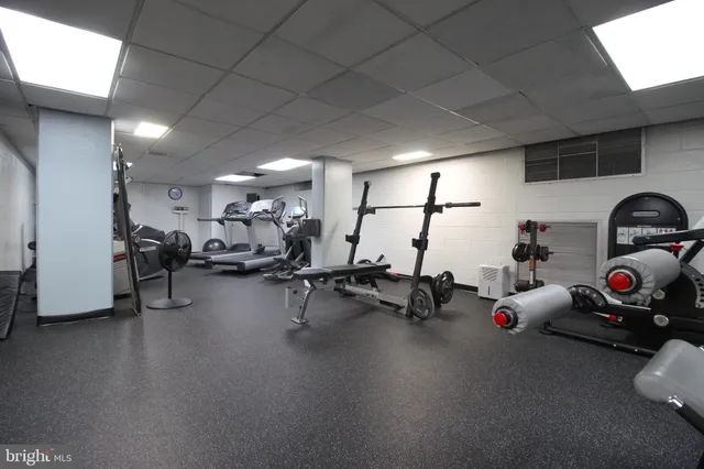 a gym room with lots of gym equipment and a window