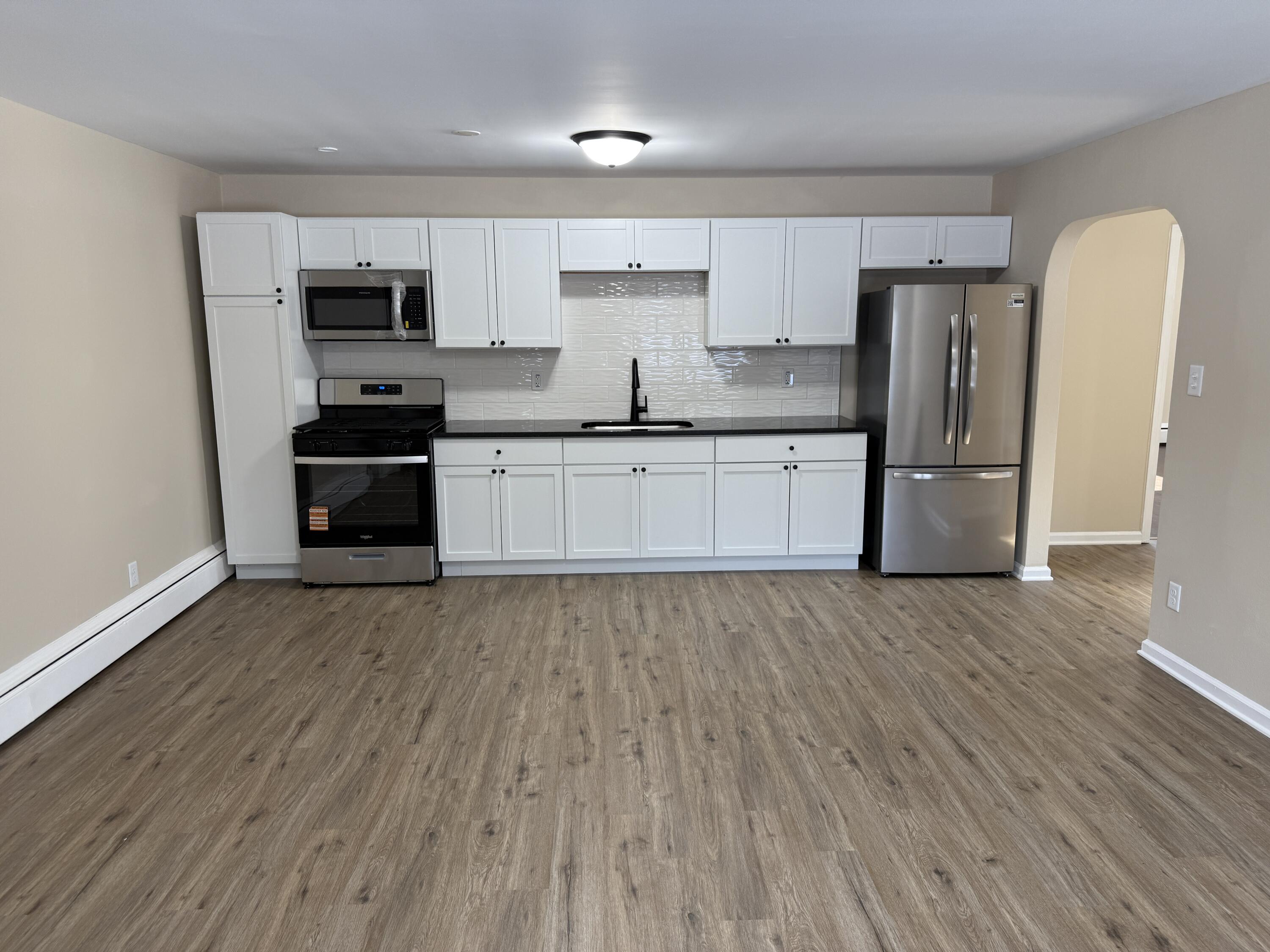 1359 State Street Hobart, IN 46342 - Photo 3 of 14 a kitchen with stainless steel appliances granite countertop a refrigerator a stove top oven a sink and dishwasher with wooden floor