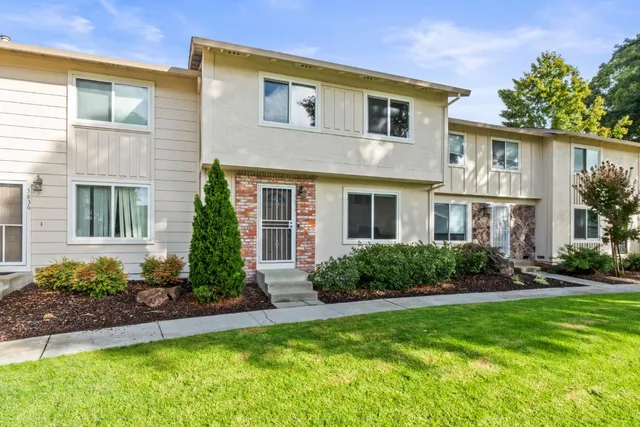 a front view of a house with a yard and plants