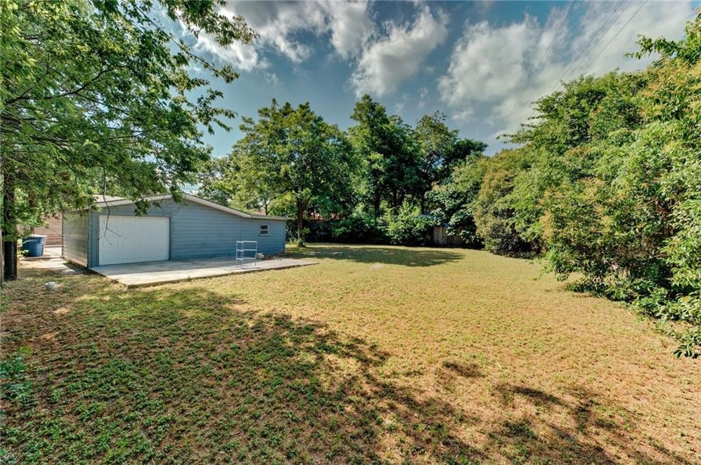 8318 Burrell Drive Austin, TX 78757 - Photo 26 of 27 View of green lawn with an outdoor structure and a detached garage