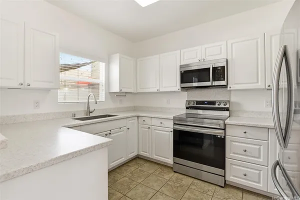 a kitchen with cabinets stainless steel appliances and a window