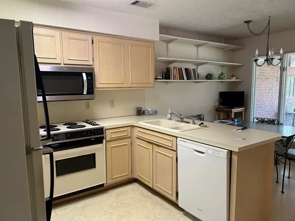a room with a sink a chandelier and a flat screen tv