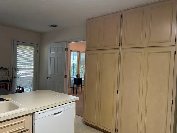 a kitchen with stainless steel appliances granite countertop a refrigerator a stove a sink dishwasher and white countertops with wooden floor